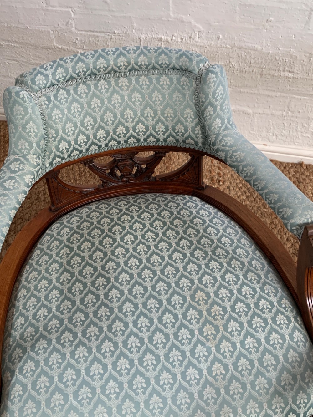 A pair of Edwardian walnut tub armchairs with pale blue patterned upholstery, turned front legs, and castors. View IV