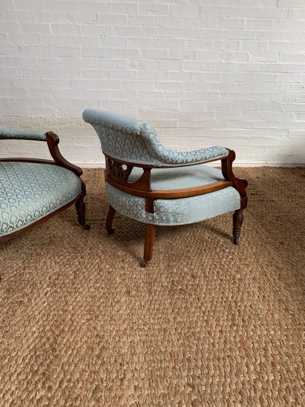 A pair of Edwardian walnut tub armchairs with pale blue patterned upholstery, turned front legs, and castors. View VIII