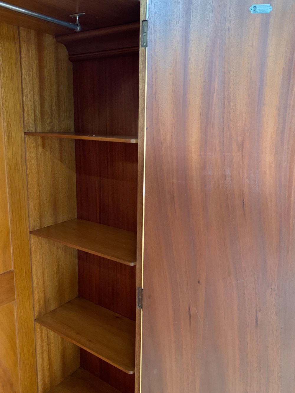 An Art Deco double wardrobe crafted from figured burr walnut veneer with rounded top edges, vertical wooden handles, and a stepped plinth base. View VII