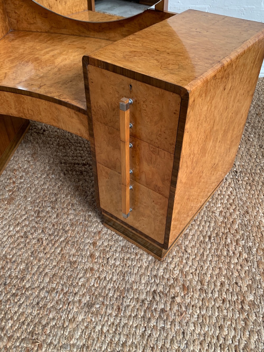 An Art Deco burr walnut dressing table featuring a circular mirror, twin pedestals, and vertical drawer handles. View V