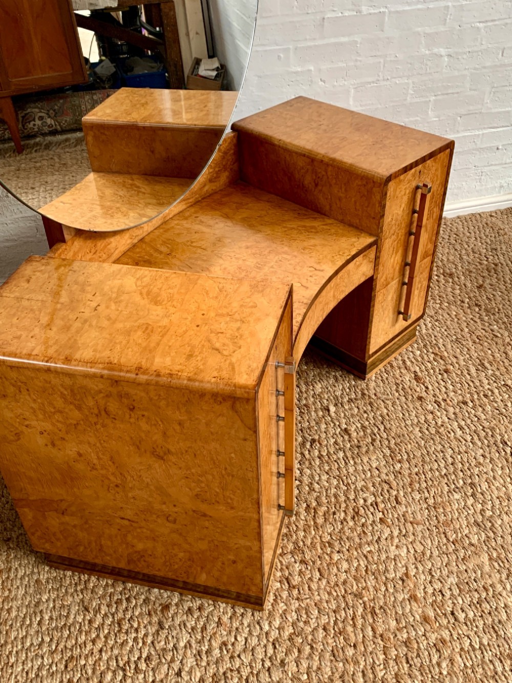 An Art Deco burr walnut dressing table featuring a circular mirror, twin pedestals, and vertical drawer handles. View X