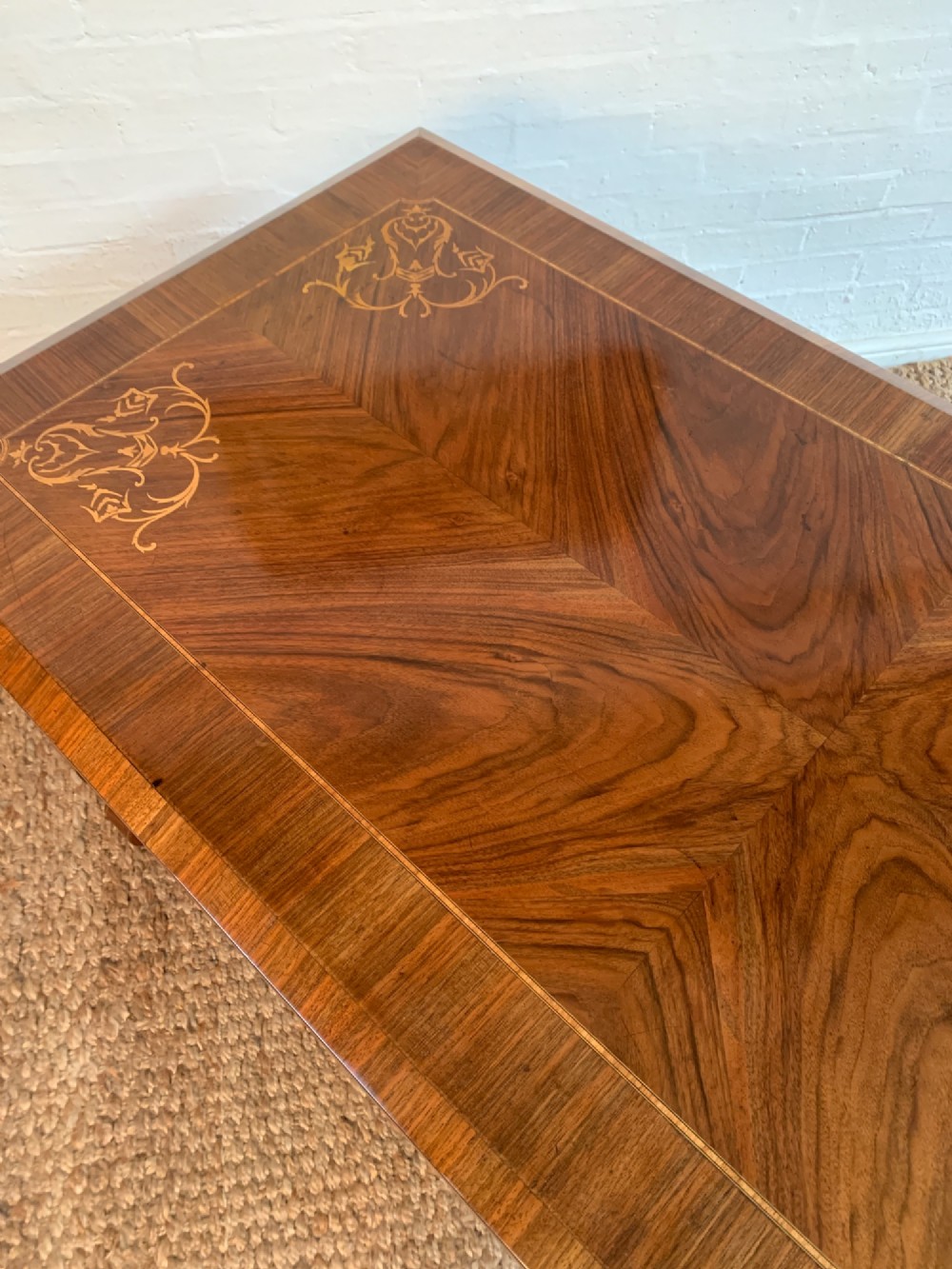 A rectangular walnut writing desk featuring decorative corner marquetry, three frieze drawers with brass pulls, curved lyre-shaped legs, and a shaped central stretcher. View VII