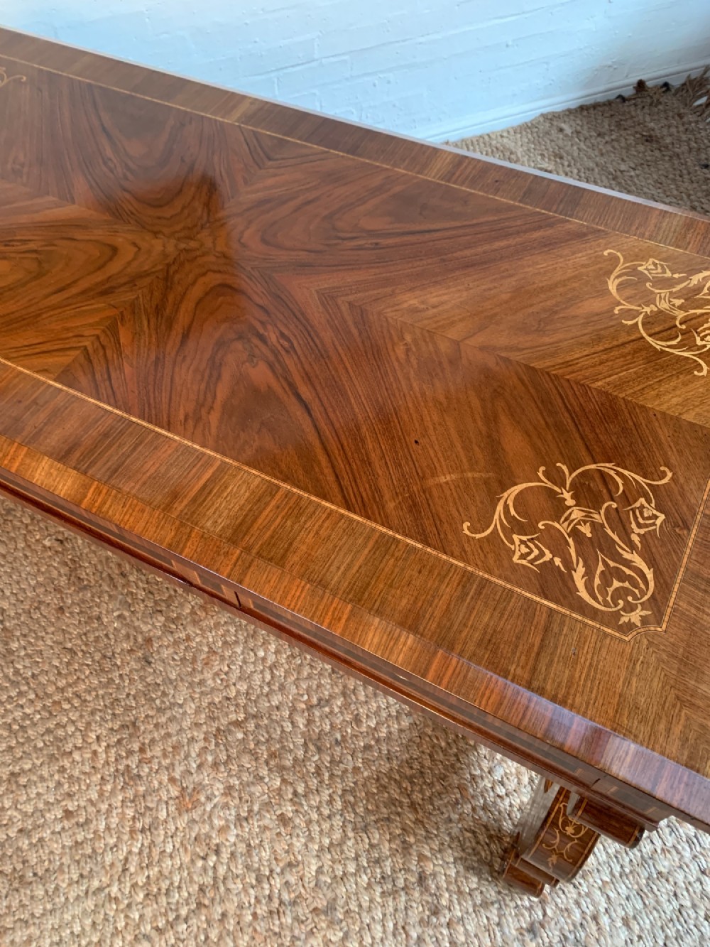 A rectangular walnut writing desk featuring decorative corner marquetry, three frieze drawers with brass pulls, curved lyre-shaped legs, and a shaped central stretcher. View VIII