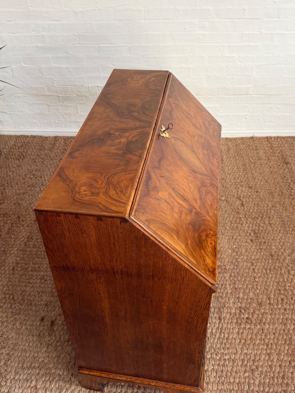 A Georgian period figured walnut bureau featuring a slant front flap above four graduated drawers with brass handles, resting on bracket feet. View VIII