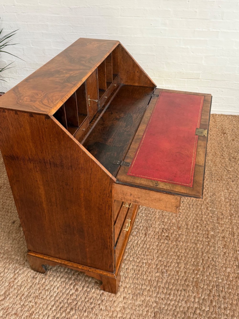 A Georgian period figured walnut bureau featuring a slant front flap above four graduated drawers with brass handles, resting on bracket feet. View IX