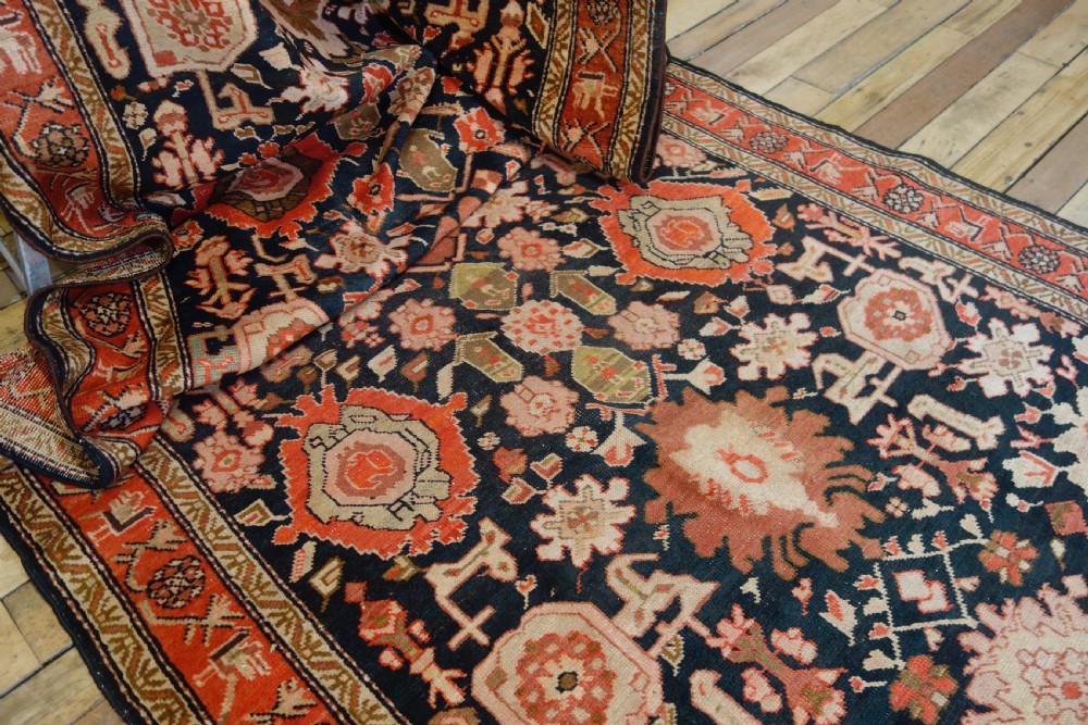 A long 19th-century Caucasian Kuba kelleh corridor runner rug featuring geometric medallions on a dark blue field framed by a terracotta border. View III