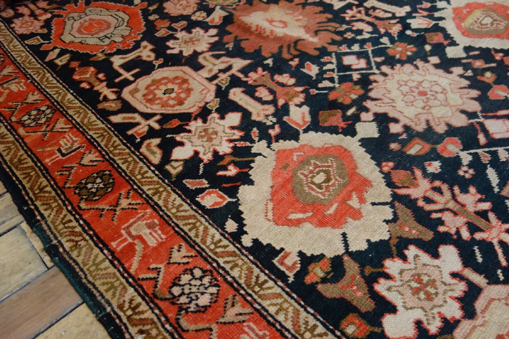 A long 19th-century Caucasian Kuba kelleh corridor runner rug featuring geometric medallions on a dark blue field framed by a terracotta border. View IV