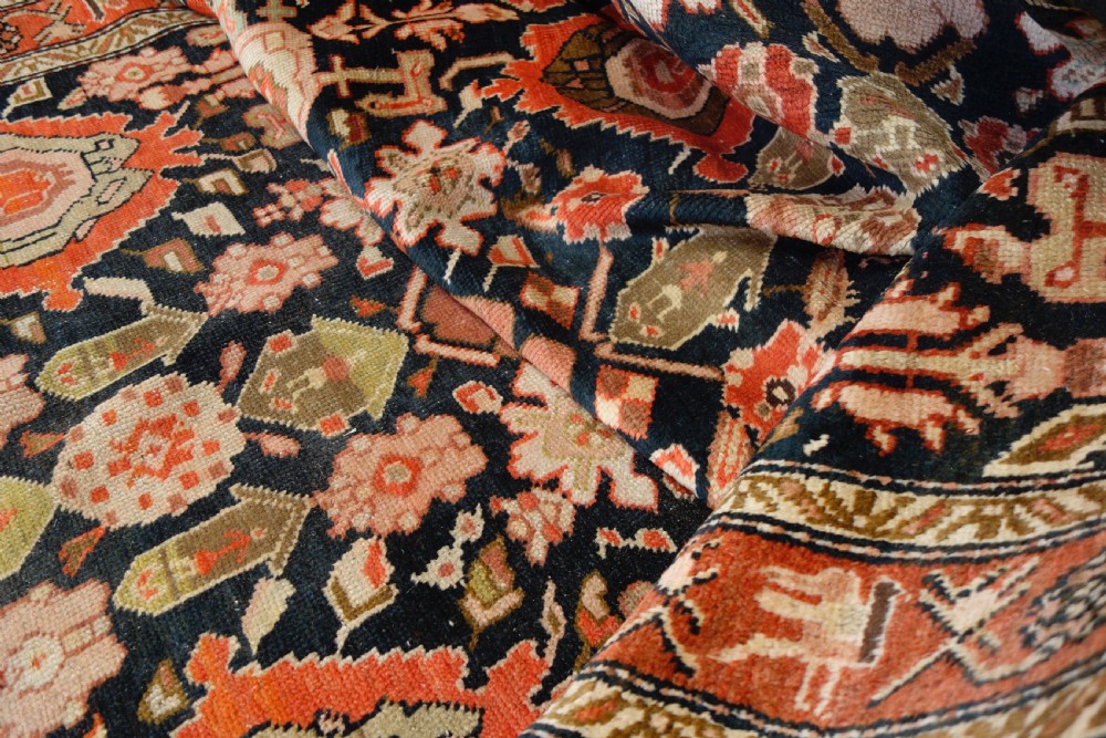 A long 19th-century Caucasian Kuba kelleh corridor runner rug featuring geometric medallions on a dark blue field framed by a terracotta border. View V