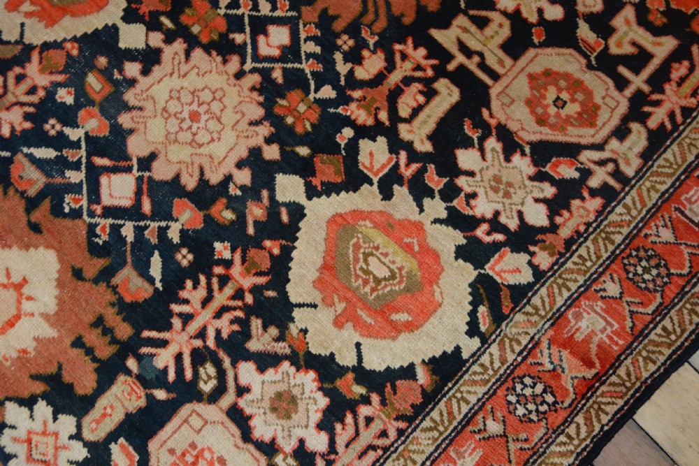 A long 19th-century Caucasian Kuba kelleh corridor runner rug featuring geometric medallions on a dark blue field framed by a terracotta border. View VI