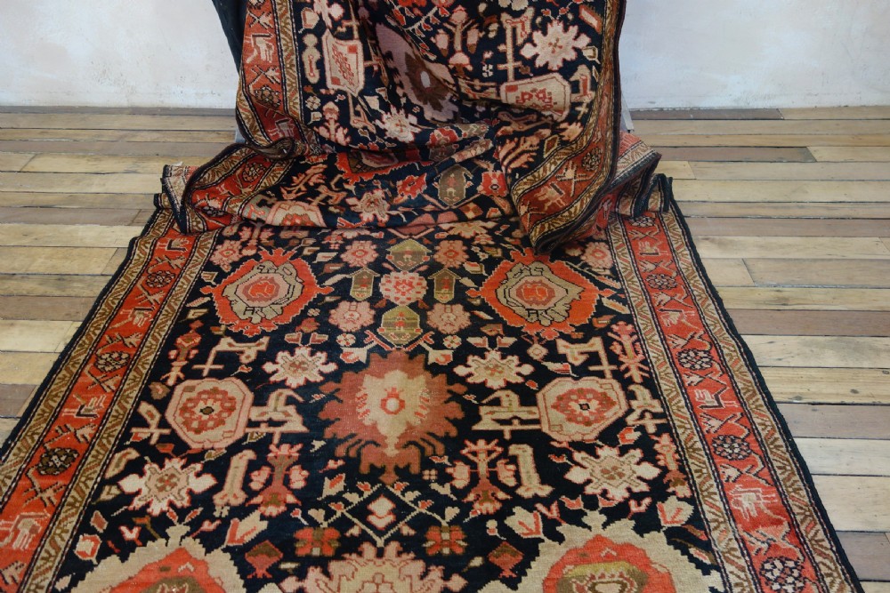 A long 19th-century Caucasian Kuba kelleh corridor runner rug featuring geometric medallions on a dark blue field framed by a terracotta border. View VIII