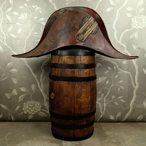 fig 1. A nineteenth-century painted toleware trade sign shaped in the form of a military bicorn hat with gilt detailing.