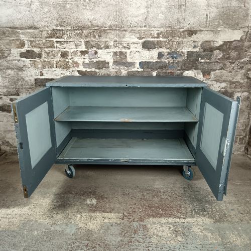 fig 2. A 19th-century wooden military transport packing case featuring a slate grey painted finish and panelled front doors set on castors.