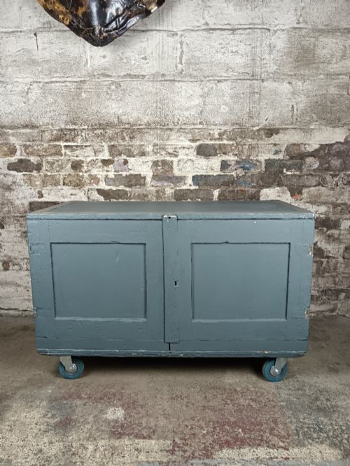 fig 1. A slate grey painted 19th-century military campaign packing chest with iron flush handles, corner reinforcements, hinged doors, and an internal shelf.