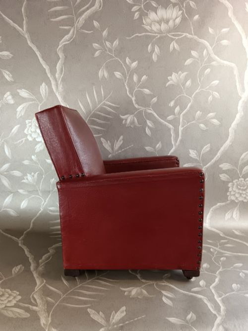 fig 2. A child-sized 1930s Art Deco club chair upholstered in oxblood red leather with studded trim along the arms.