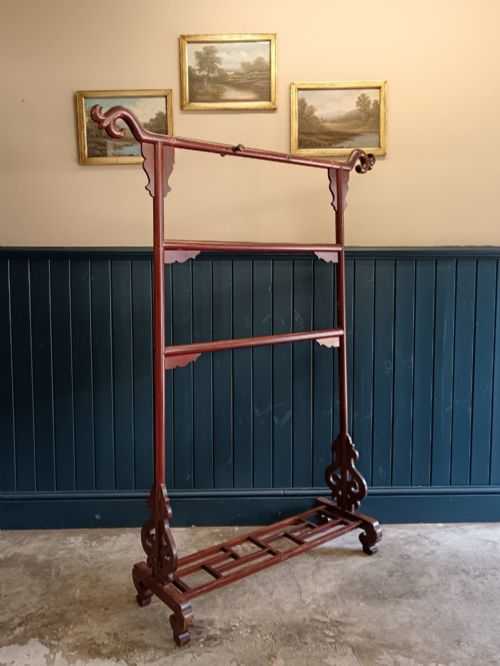 fig 1. A late 19th-century Chinese red lacquered wooden robe stand with carved scroll terminals, horizontal crossbars, and a lower latticework base.
