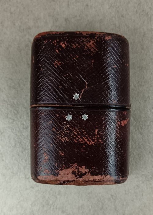 fig 1. A Victorian folding campaign cutlery set featuring silver-plated utensils with light-coloured handles, a clear glass beaker, and a fitted dark red morocco leather carrying case.