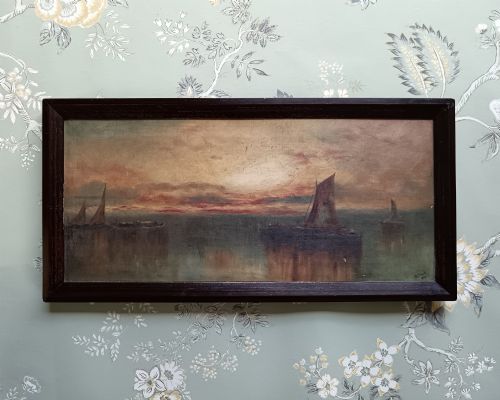 fig 2. A pair of framed horizontal Edwardian oil paintings depicting atmospheric maritime scenes with sailboats at sunrise and sunset.