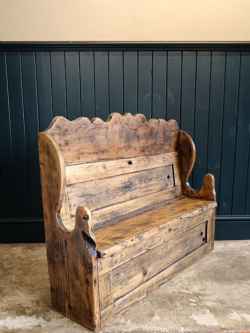 fig 2. An antique 19th-century country pine and elm settle bench with a high scalloped cresting rail and a warm brown waxed timber finish.