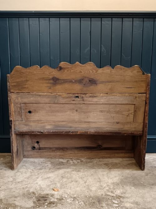 fig 3. An antique 19th-century country pine and elm settle bench with a high scalloped cresting rail and a warm brown waxed timber finish.