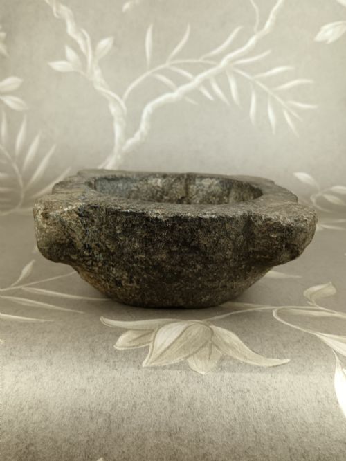 fig 2. An antique hand-carved stone mortar featuring four corner lugs, shown with a turned fruitwood pestle.