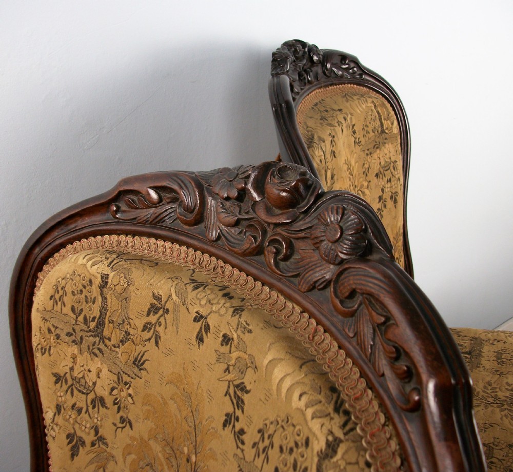 A set of four Victorian rosewood dining chairs featuring carved cartouche backs, patterned landscape upholstery, and cabriole legs on castors. View II