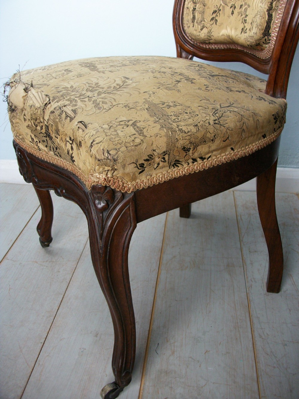 A set of four Victorian rosewood dining chairs featuring carved cartouche backs, patterned landscape upholstery, and cabriole legs on castors. View III