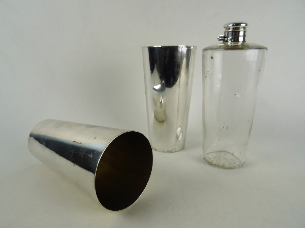 A nineteenth-century glass spirit flask encased in a dark brown leather carrying case with a leather shoulder strap and silver-toned metal cap. View II