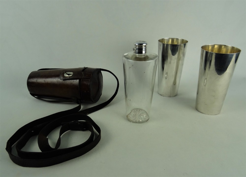 A nineteenth-century glass spirit flask encased in a dark brown leather carrying case with a leather shoulder strap and silver-toned metal cap. View IX