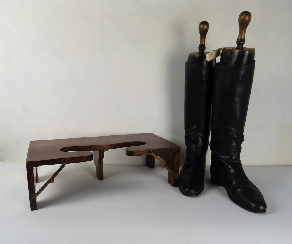 A Victorian folding mahogany campaign boot jack with brass folding stays and a shaped heel cutout.