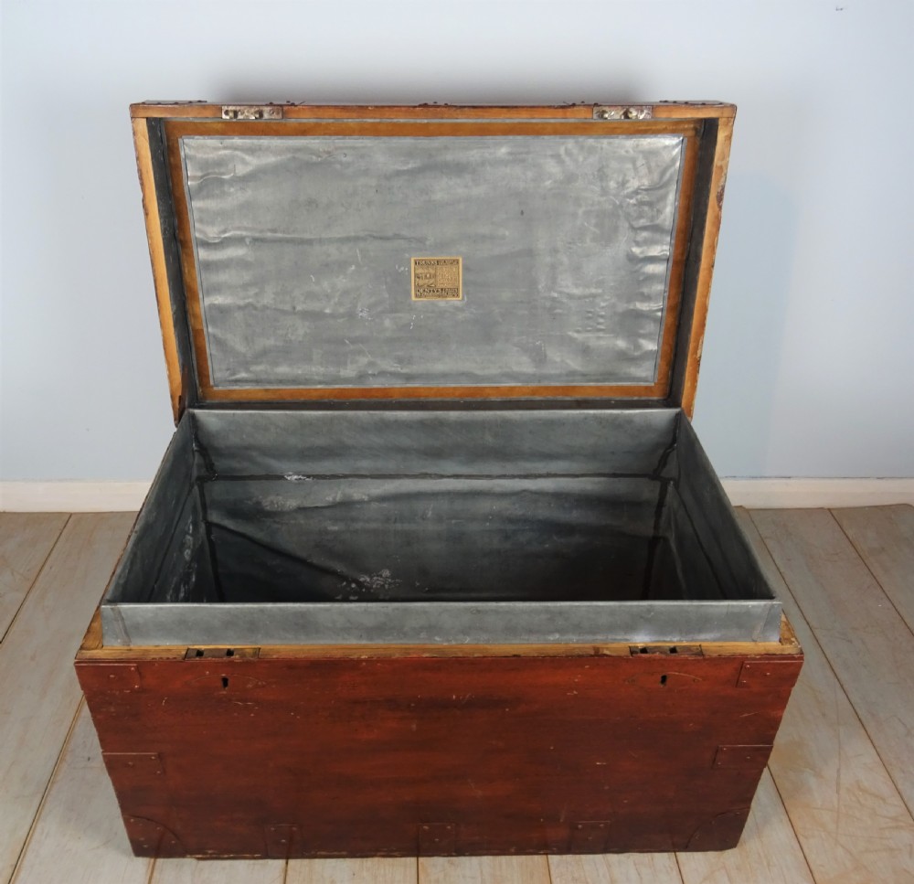 A large 19th-century dark timber campaign trunk featuring metal corner strapping, side carrying handles, and a hinged lid. View XIV