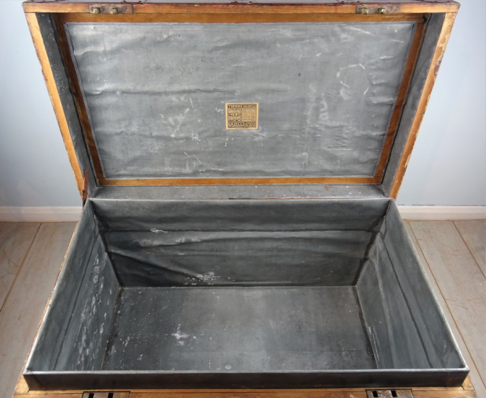 A large 19th-century dark timber campaign trunk featuring metal corner strapping, side carrying handles, and a hinged lid. View II