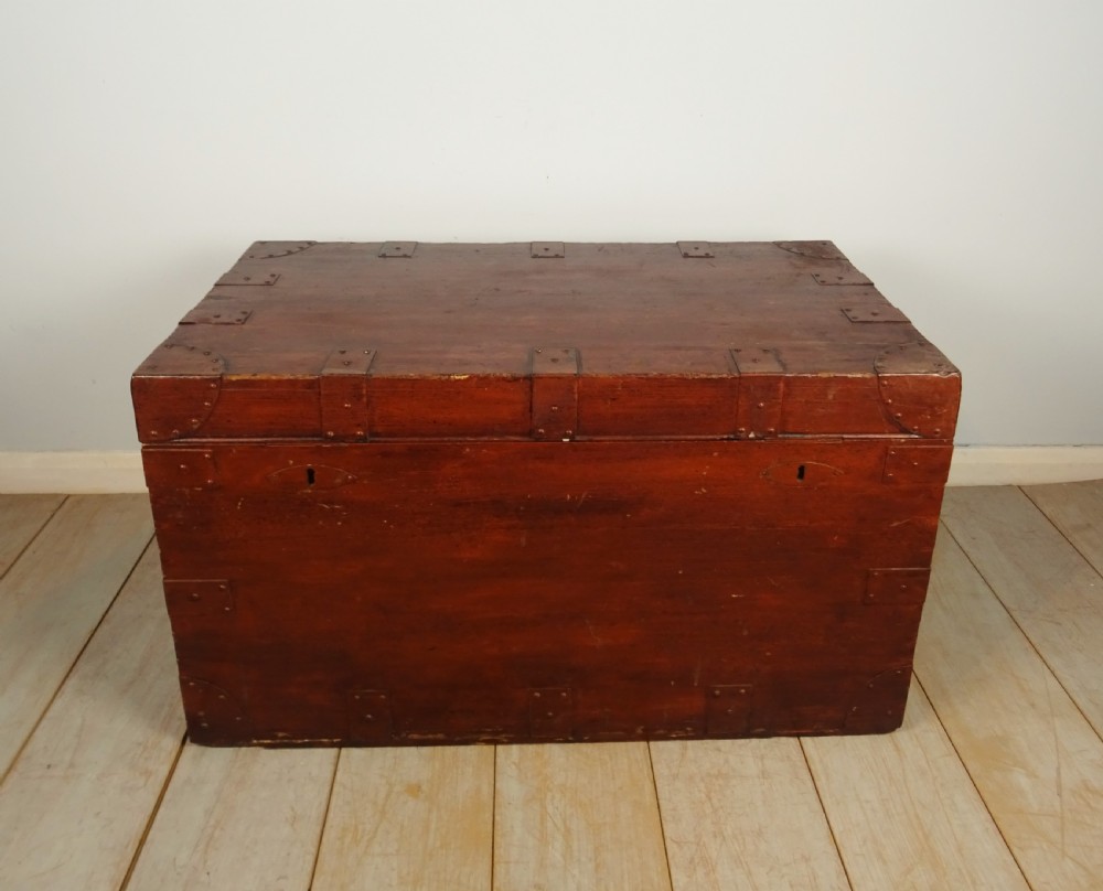 A large 19th-century dark timber campaign trunk featuring metal corner strapping, side carrying handles, and a hinged lid. View V