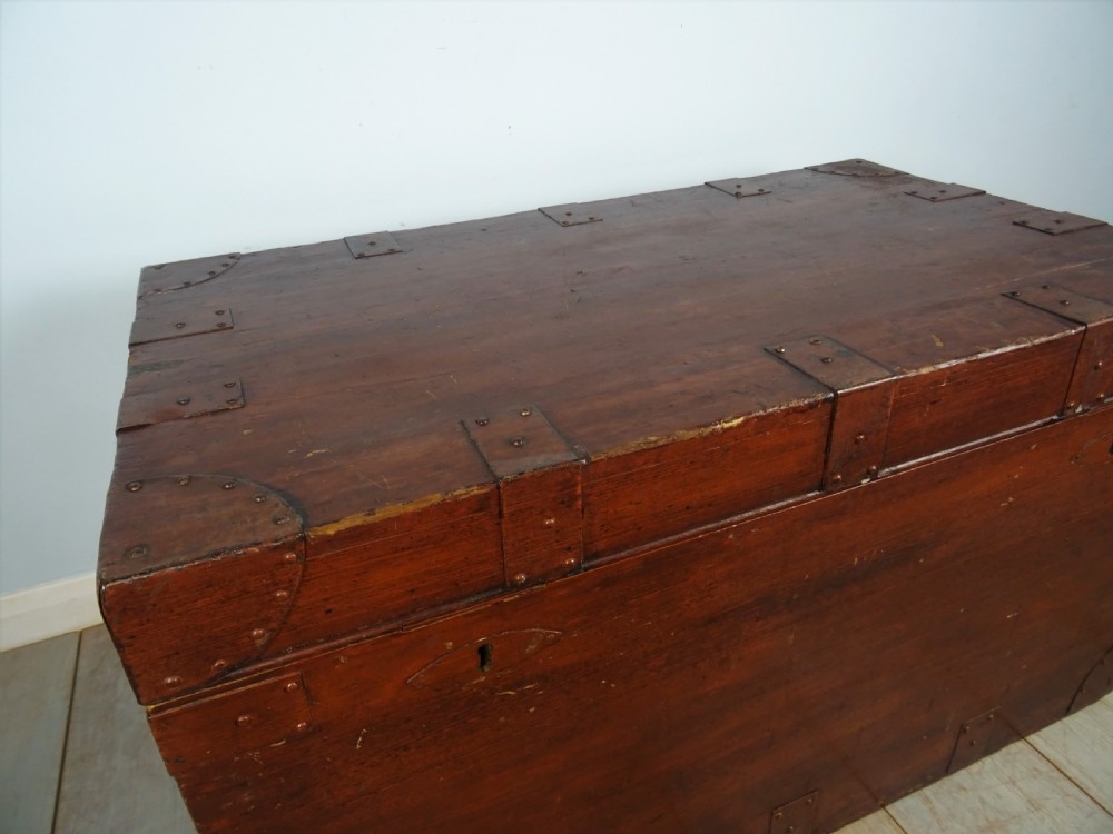 A large 19th-century dark timber campaign trunk featuring metal corner strapping, side carrying handles, and a hinged lid. View VII
