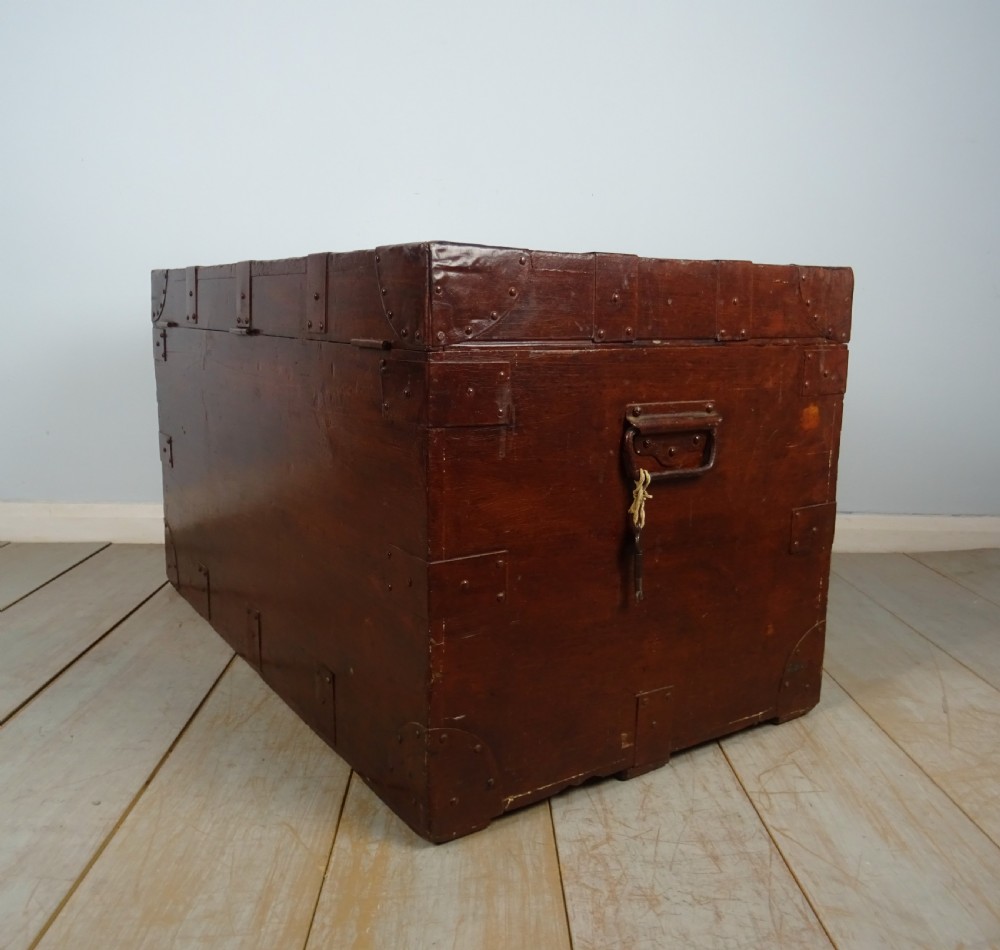 A large 19th-century dark timber campaign trunk featuring metal corner strapping, side carrying handles, and a hinged lid. View XVIII