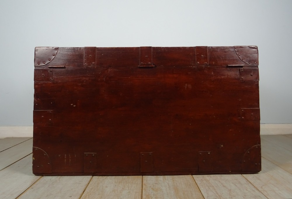 A large 19th-century dark timber campaign trunk featuring metal corner strapping, side carrying handles, and a hinged lid. View XI