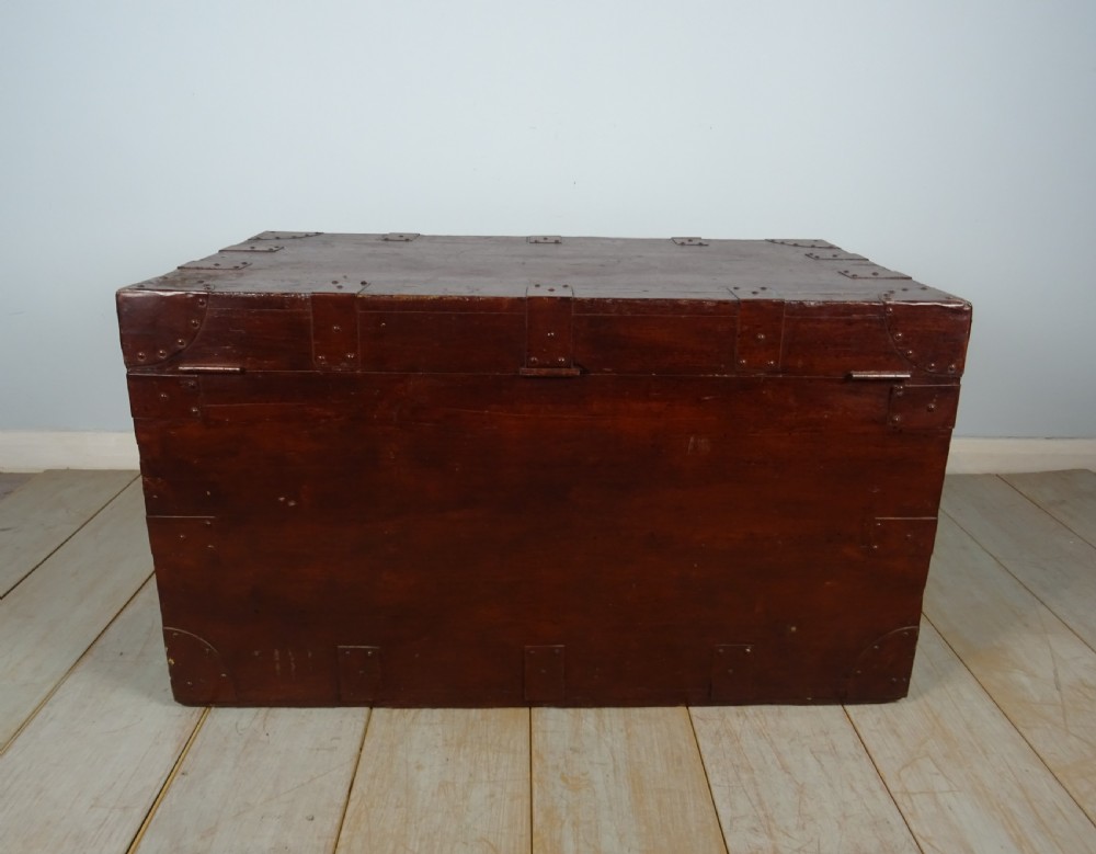 A large 19th-century dark timber campaign trunk featuring metal corner strapping, side carrying handles, and a hinged lid. View XII