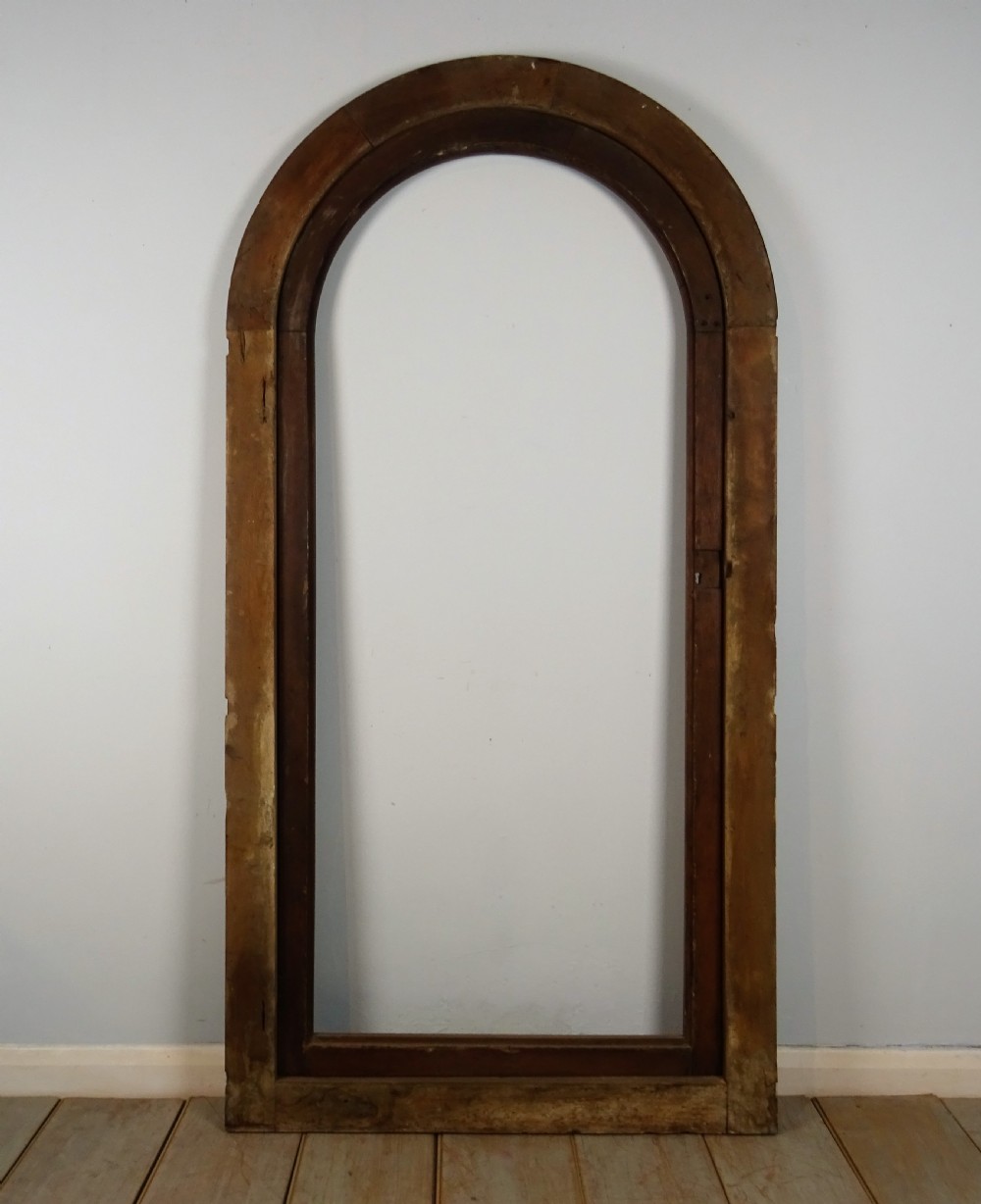 A group of three antique Italian walnut wooden door frames featuring rounded arches and moulded profiles. View VIII