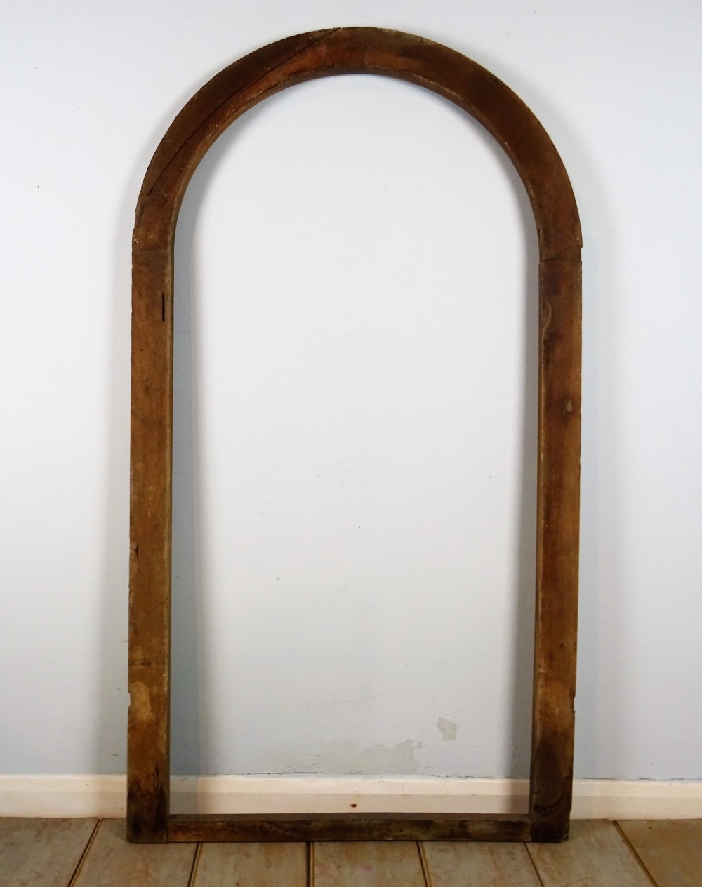 A group of three antique Italian walnut wooden door frames featuring rounded arches and moulded profiles. View XII