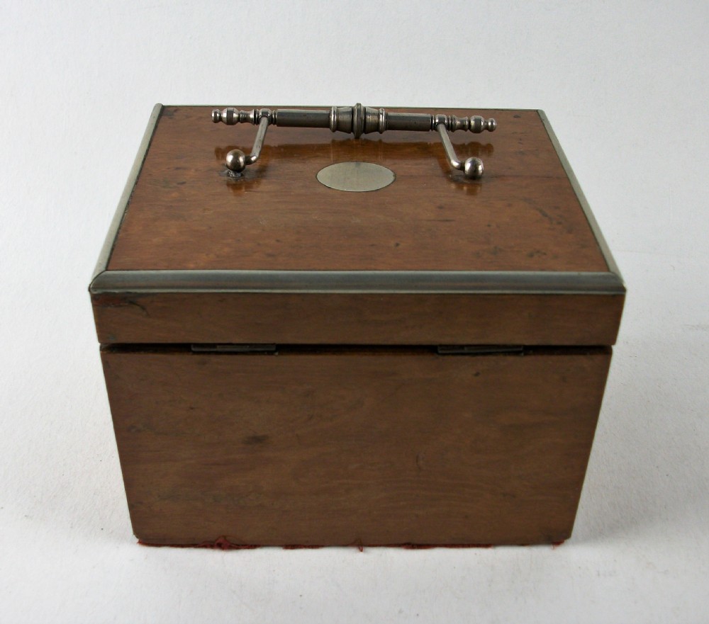 A rectangular antique burr maple wooden tea caddy featuring metal trim, a lid handle, an oval central cartouche, and a keyhole escutcheon. View II