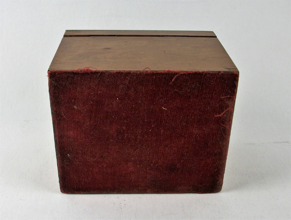 A rectangular antique burr maple wooden tea caddy featuring metal trim, a lid handle, an oval central cartouche, and a keyhole escutcheon. View IX