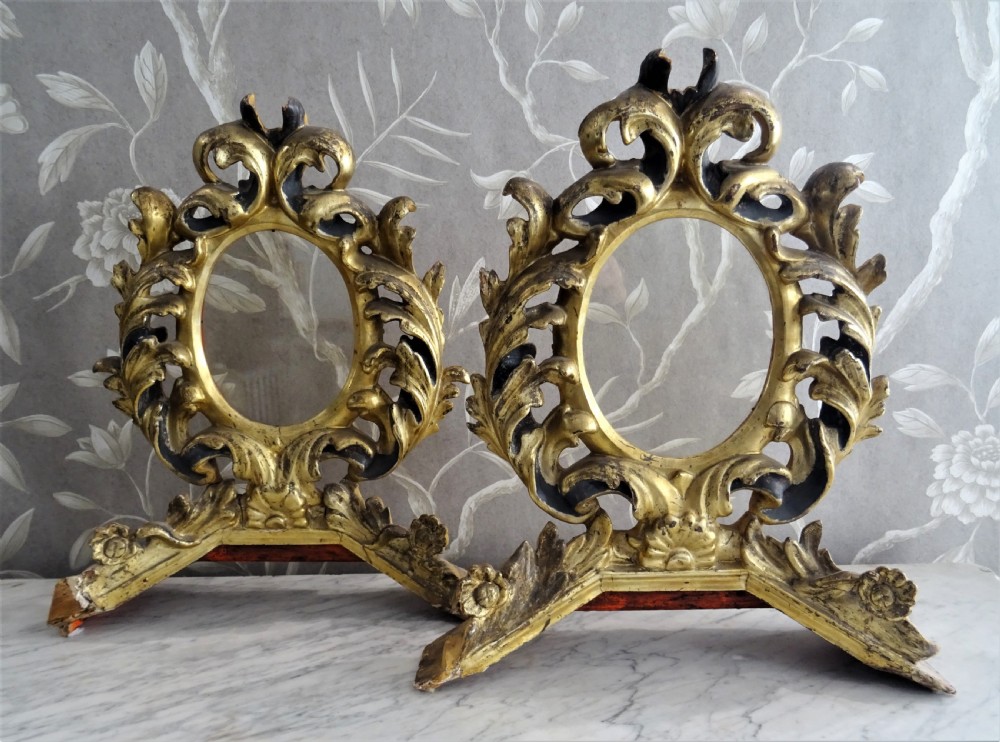 A pair of antique Italian Baroque carved giltwood oval frames with intricate acanthus leaf ornamentation and integrated standing bases. View XIV