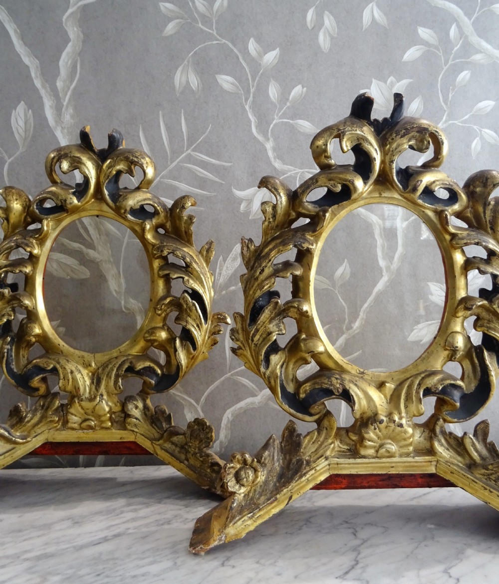A pair of antique Italian Baroque carved giltwood oval frames with intricate acanthus leaf ornamentation and integrated standing bases. View XII