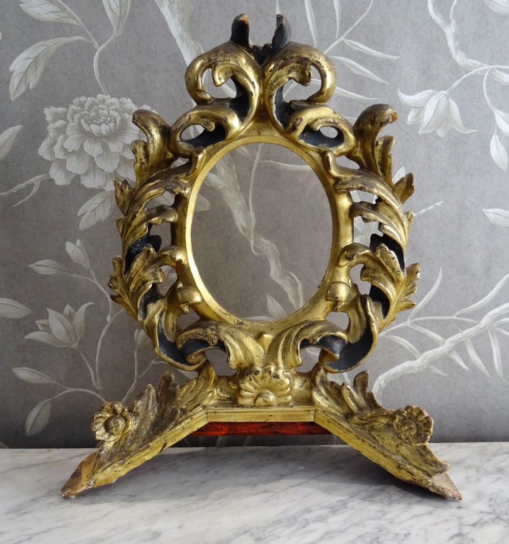 A pair of antique Italian Baroque carved giltwood oval frames with intricate acanthus leaf ornamentation and integrated standing bases. View XIII