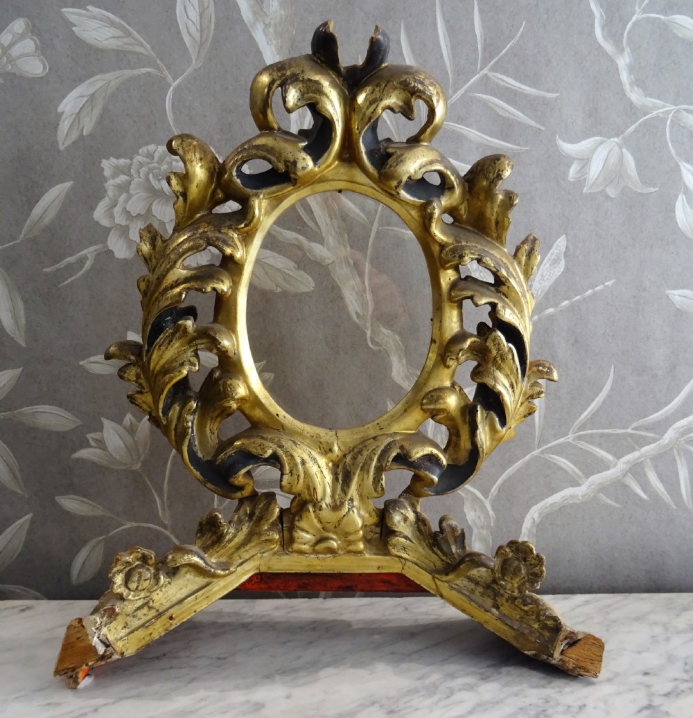 A pair of antique Italian Baroque carved giltwood oval frames with intricate acanthus leaf ornamentation and integrated standing bases. View V