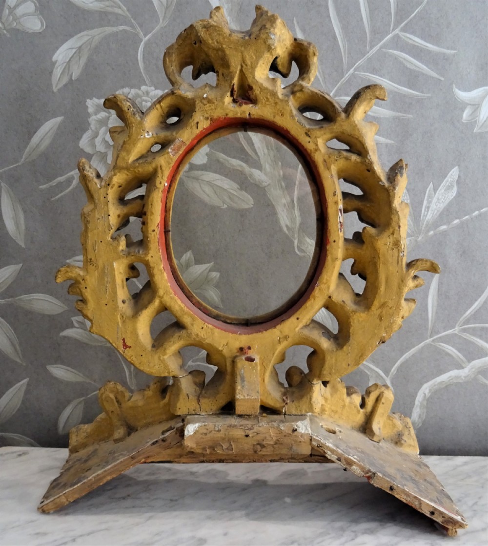 A pair of antique Italian Baroque carved giltwood oval frames with intricate acanthus leaf ornamentation and integrated standing bases. View VI