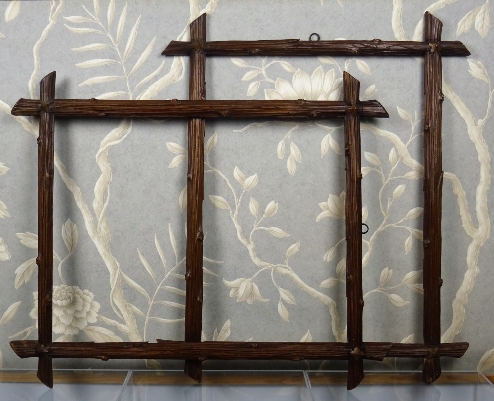 A pair of hand-carved dark brown wood picture frames designed with realistic overlapping branch motifs and bark textures.