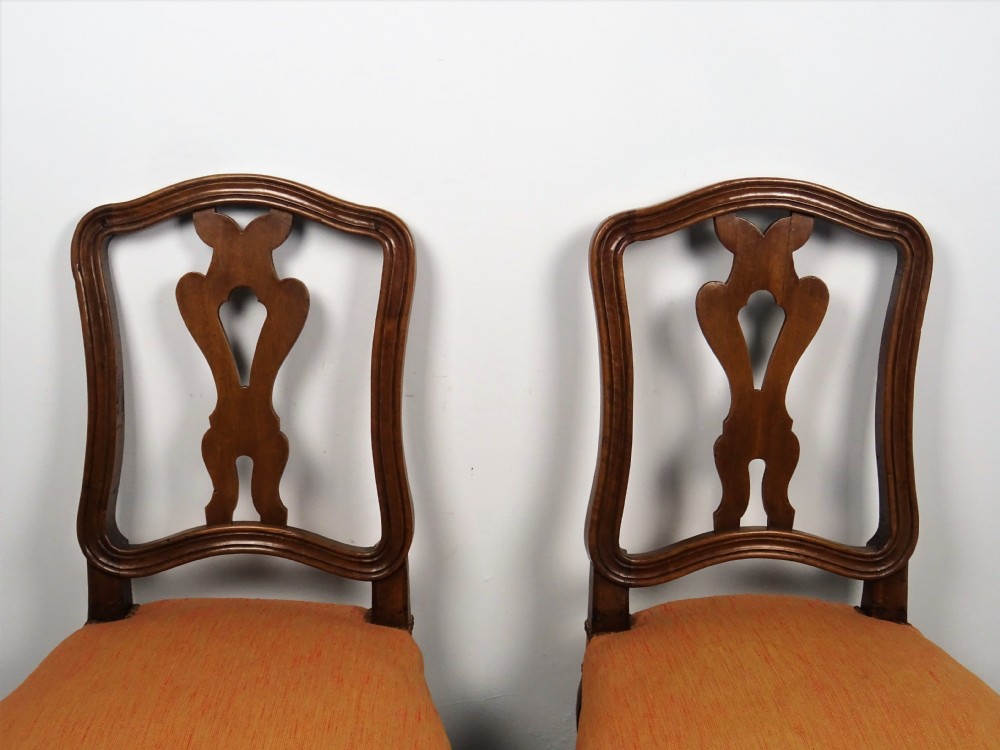 A pair of mid-18th century Italian walnut side chairs featuring carved openwork backsplats, moulded crest rails, fabric upholstered seats, and cabriole legs. View VII