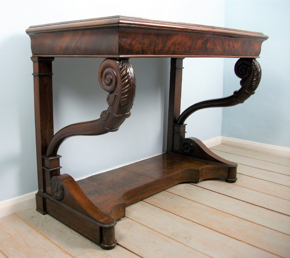 An Italian mahogany console table featuring S-scroll carved legs, a low plinth base, and a grey and white marble top. View VIII