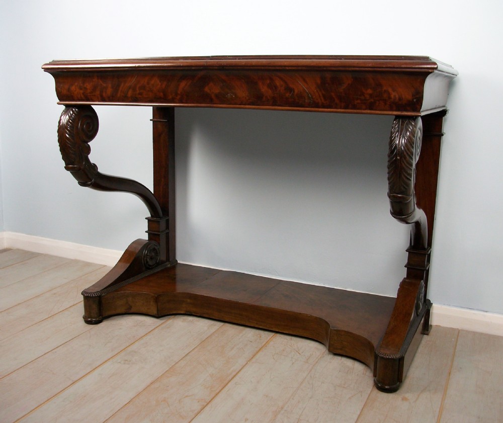 An Italian mahogany console table featuring S-scroll carved legs, a low plinth base, and a grey and white marble top. View VII