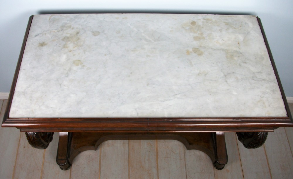 An Italian mahogany console table featuring S-scroll carved legs, a low plinth base, and a grey and white marble top. View V
